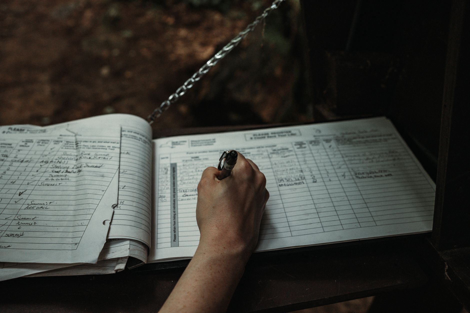 close up of a man writing in a book